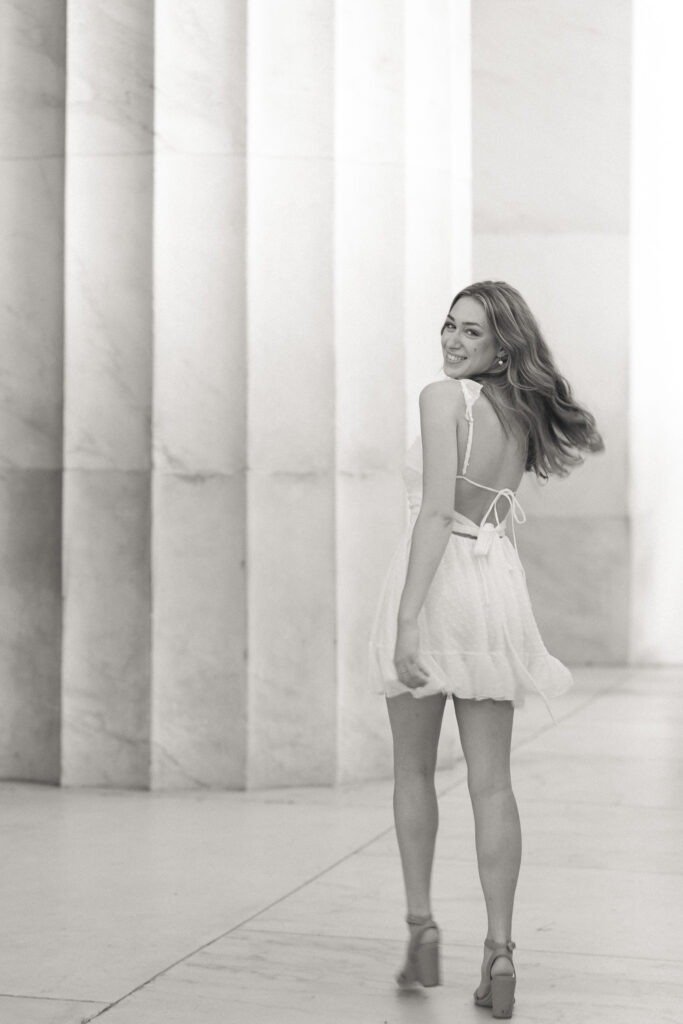 high school girl posing for her senior portraits at the lincoln memorial in washington d.c.