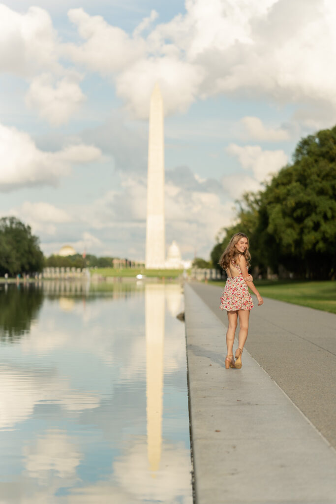 high school girl posing for her senior portraits at the reflecting pool in washington d.c.